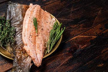 Baked Trout fillet, roasted fish on a plate with thyme and rosemary. Wooden background. Top view. Free space for your text