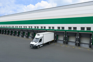 Truck near loading dock of warehouse outdoors, aerial view. Logistics center