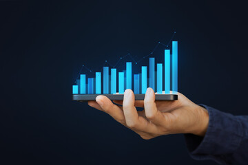 Hand holding smartphone or mobile phone with growth business graph. Business economic and technology concept