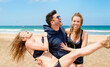 © ADDICTIVE STOCK - Cheerful friends having fun on sandy beach during vacation