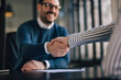 © bnenin - Close up of a smiling male and female, shaking hands.