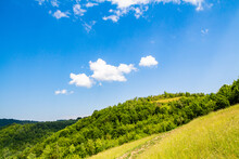 Landscape Of Hills Covered With Trees And A Moat On A Summer Day. Clear Blue Sky.