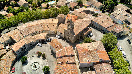 Sticker - Aerial shot of a medieval round village with red tile roofs surrounded by green fields and trees