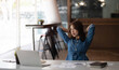 © wichayada - Asian woman enjoy and happy of relaxing at the office. Hold hands behind head concept of success future.