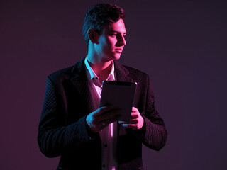 Poster - Young investor. Man investor on dark background. Businessman thought. Investor with tablet computer in his hands. Guy is dressed in business suit. Manager is standing in studio. Young successful man