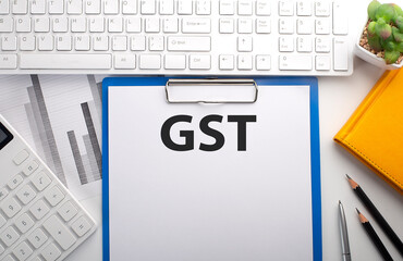Poster - GST written on paper with keyboard, chart, calculator and notebook