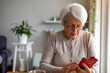 © pikselstock - Portrait of senior woman using smartphone at home
