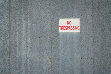 Red And White No Trespassing Sign On A Galvanized Metal Building Wall