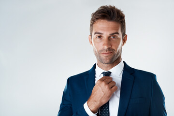 Poster - Straighten up and fly right. Portrait of a confident young businessman wearing a suit while standing against a grey background.