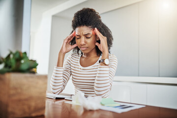 Poster - Headache, please go away. Shot of a young woman suffering with a headache while working at home.