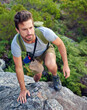 © Anne B/peopleimages.com - Heading in the right direction. Shot of a handsome young man scaling a mountain.