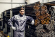 Leinwandbild Motiv Portrait of proud metallurgy worker leaning on metal framework in steel factory.