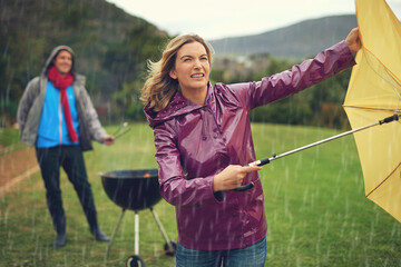 Canvas Print - We wont let a little bad weather stop our barbeque. Shot of a couple trying to barbecue in the rain.