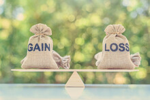 Capital Investment Gain And Loss, Financial Concept : Gain And Loss Bags On A Basic Balance Scale, Depicts Balancing Between Profit And Loss While Managing Assets E.g Bonds, Stocks, Derivatives, ETFs