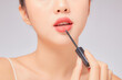 © Tuan  Nguyen  - Front view of model using lipstick in white background for cosmetic advertising