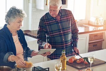 Wall Mural - Next, we have to dice the tomatoes.... Cropped shot of a senior couple using a digital tablet while cooking together in their kitchen at home.