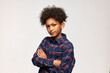© Anatoliy Karlyuk - Horizontal portrait of bossy displeased and discontent serious African American boy of 13-years-old standing against white background with folded arms. Human emotions and feeling, body language