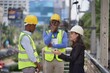 © Stock Media Labs - Woman engineer wearing a white helmet while meeting with foreman at construction site. architecture and engineering concept.