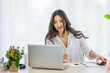 © Bangkok Click Studio - Asian young beautiful happy professional successful businesswoman designer sitting smiling at workstation desk using laptop notebook computer and smartphone working remotely online at home office