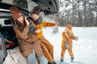 © fotofabrika - Lovely smiling couple sitting in car trunk in winter forest