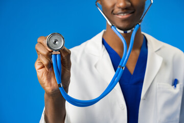 Cropped photo of black medical doctor with stethoscope on blue