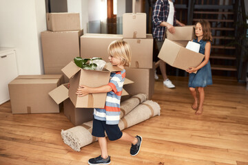 Poster - We all help out together as a family. Shot of a young family on their moving day.