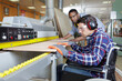 © auremar - disabled carpenter in wheelchair with his colleague