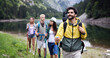 © NDABCREATIVITY - Group of young friends hiking in countryside. Multiracial happy people travelling