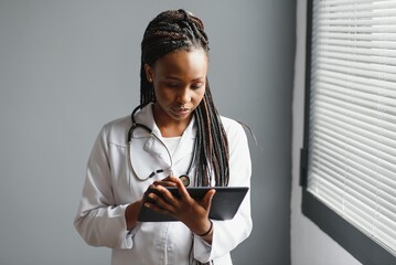 Wall Mural - Portrait Of Smiling Female Doctor Wearing White Coat With Stethoscope In Hospital Office