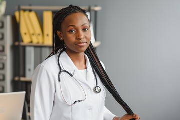 Wall Mural - Portrait Of Smiling Female Doctor Wearing White Coat With Stethoscope In Hospital Office