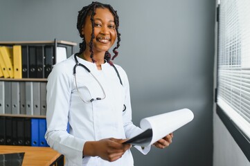 Wall Mural - Portrait Of Female Doctor Wearing White Coat In Office