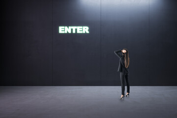 Poster - Thoughtful young businesswoman standing in concrete interior with entrance to success. Way and opportunity concept.
