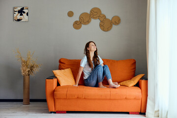 Poster - woman on the orange couch in the rest room posing apartments