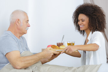 care worker giving lunch to senior