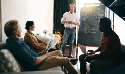Poster - Hes got a master plan to present to the team. Shot of a businessman giving a presentation to his colleagues in an office.
