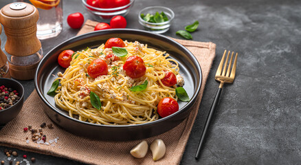 Wall Mural - Pasta with feta, cherry tomatoes and basil on a dark background with spices.