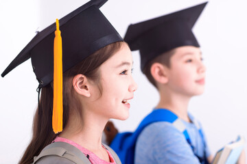 Wall Mural - Side view of Happy boy and  girl in graduation cap holding books