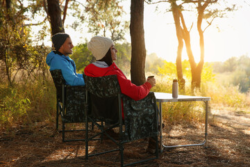 Sticker - Couple resting in camping chairs and enjoying hot drink outdoors