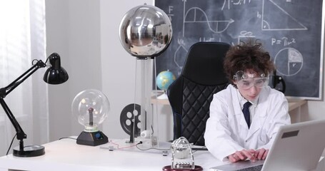 Wall Mural - education, science and kids concept - boy wearing goggles for physics lab doing electrical tests. ch