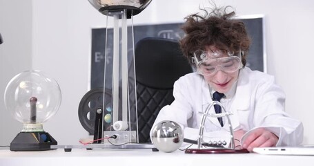Wall Mural - education, science and kids concept - boy wearing goggles for physics lab doing electrical tests. ch