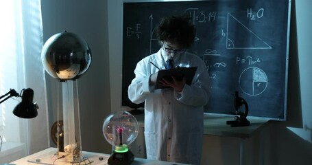Wall Mural - physics science lab: handsome young scientist in white coat and glasses doing electrical tests. chil