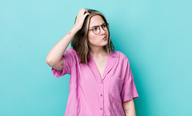 Wall Mural - pretty caucasian woman feeling puzzled and confused, scratching head and looking to the side