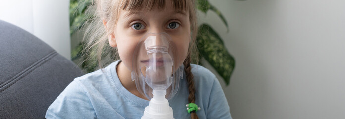 sick little girl makes inhalation over grey background with copy space. Girl making inhalation with nebulizer at home. child asthma inhaler inhalation nebulizer steam sick cough