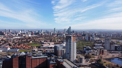 Drone image of Salford Quays with modern buildings and landmarks and views towards Manchester. 