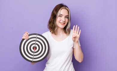 Wall Mural - pretty caucasian woman smiling and looking friendly, showing number four. dart target concept