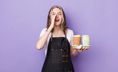 pretty caucasian woman feeling happy,giving a big shout out with hands next to mouth. take away coffee concept