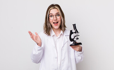 Wall Mural - pretty caucasian woman feeling happy, surprised realizing a solution or idea. scientist with microscope concept