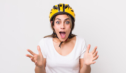 Wall Mural - pretty hispanic woman feeling extremely shocked and surprised. bicycle concept