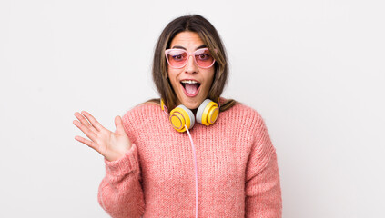 Wall Mural - pretty hispanic woman feeling happy, surprised realizing a solution or idea. headphones concept