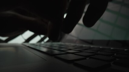 man writes message to social network. male hands typing on notebook keyboard in dark . writer writes